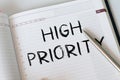 HIGH PRIORITY text on notebook with pen on white background Royalty Free Stock Photo