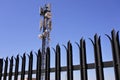 High protective sharp metal fence in front of a tall.Telecommunication Antenna Tower