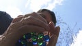 High quality close-up of a man holding blue and green glass marbles and putting balls on a glass top table, view from the bottom, Royalty Free Stock Photo