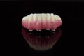 High-quality dental prosthesis made by dental technician, prosthesis with a pink gingiva to fix after implantation.