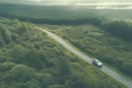 A high quality image depicting a car navigating through a dense woodland from an aerial perspective.