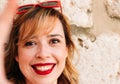 High quality image portrait of a beautiful young woman taking a selfie on the street with her smartphone. Red lipstick