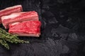 High-quality meat preparation. Raw beef cut with herbs and spices on a black textured background. Copy space provided. Royalty Free Stock Photo
