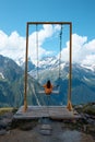 a girl rides a swing in the mountains, a landscape of mountains, alpine meadows and peaks in ice