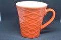 Orange ceramic coffee mug with wave pattern