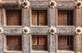 High res antique pale weathered brown wooden door with geometric symmetrical square decoration close up texture background