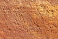old muted pale gradient rich orange earth tone rough textured sandstone wall with darker scratches markings, texture background Royalty Free Stock Photo