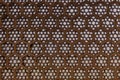 High res smooth antique dark brown Indian floral pattern inside honeycomb shaped see through carved wall