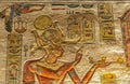 well preserved ancient red limestone Egyptian vividly painted wall relief with a detailed god and hieroglyphs