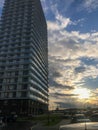 High residential block of flats, column in the city center. house of a new format, white, without a balcony with a glass terrace Royalty Free Stock Photo