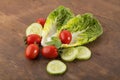 Vegetable: Fresh Green Romaine Lettuce with Baby Tomatoes, Mint Leaves and Cucumber Slices on Brown Wooden Background Royalty Free Stock Photo