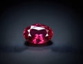 Exquisite Oval-Cut Ruby Gemstone, Isolated on Dark Reflective Surface Royalty Free Stock Photo