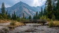 A stunning image of Small Wooden Bridge Over Dry Riverbed with Mountain Range Background. Royalty Free Stock Photo