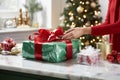 Festive Gift Wrapping Delight: Hands Expertly Tying Ribbon on Perfectly Wrapped Box