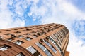 High-rise brick house and white clouds in blue sky Royalty Free Stock Photo