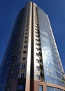 High-rise building against the blue sky, bottom view in perspective. A modern building with apartments and offices, fashionable Royalty Free Stock Photo