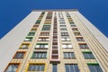 A high-rise building against a blue sky. A new high-rise residential building with a colorful facade