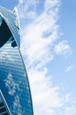 high-rise building with blue glass facade against a light blue sky with clouds, copy space, text Royalty Free Stock Photo