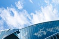 high-rise building with blue glass facade against a light blue sky with clouds, copy space, text Royalty Free Stock Photo