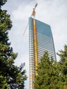 High-rise building under construction. New house with glass facade. The crane is attached to a skyscraper Royalty Free Stock Photo