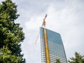 High-rise building under construction. New house with glass facade. The crane is attached to a skyscraper Royalty Free Stock Photo