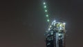 High-rise building under construction night timelapse. The site with cranes against blue sky