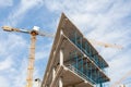 High-rise building under construction. The site with cranes against blue sky Royalty Free Stock Photo