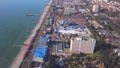 High-rise buildings located on coast on background of sea. Clip. Top view of developed tourist city by sea in summer