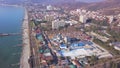 High-rise buildings located on coast on background of sea. Clip. Top view of developed tourist city by sea in summer
