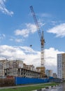 High-rise crane on the construction of a multi-apartment high-rise residential building in the city on the street Royalty Free Stock Photo