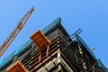 high-rise crane supplies material to a high-rise building Construction site with two cranes Royalty Free Stock Photo