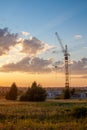 High-rise cranes build a house on the background of a beautiful sunset Royalty Free Stock Photo