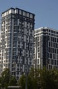 A high-rise gray building against a blue sky. Modern high-rise residential buildings in the city. Beautiful decoration of the Royalty Free Stock Photo