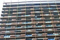 Modern high-rise residential building under construction with scaffolding and decorative safety net Royalty Free Stock Photo