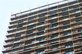 High-rise modern multi-apartment residential building under construction with scaffolding and decorative safety net Royalty Free Stock Photo