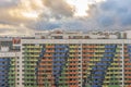 High-rise multi-storied residential buildings with loggias and windows against cloudy sky at sunset. Beautiful colorful urban