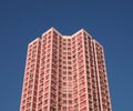 High-rise pink residential building with a modern design set against a blue sky. Royalty Free Stock Photo