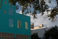 High-rise reflections in windows of aqua painted building on 3rd street