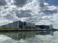 High-rise tenement buildings reflected on a huge and murky river under thick dark clouds.