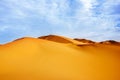 High sand dunes of the Sahara desert against a blue sky with clouds Royalty Free Stock Photo