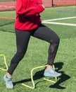 High school female steping over mini hurdles Royalty Free Stock Photo