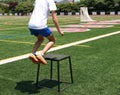 Boy in the air jumping on to a black plyo box Royalty Free Stock Photo