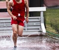 High school boy racing in the steeplechase Royalty Free Stock Photo