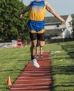 High school boy triple jumping during competition