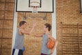 High school boys with basketball giving a high five Royalty Free Stock Photo