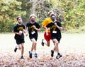 High school boys running in a cross country race wearing face mask protection from COVID-19
