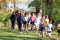 High school boys running downhill emerging from the woods in a 5K cross country race Royalty Free Stock Photo