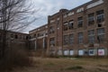 high-school, with broken windows and graffiti on the walls, looking abandoned and eerie