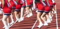 High school cheerleaders cheering on the sidelines during a football game
