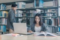High school or college students studying and reading together in library. Student use laptop at library Royalty Free Stock Photo